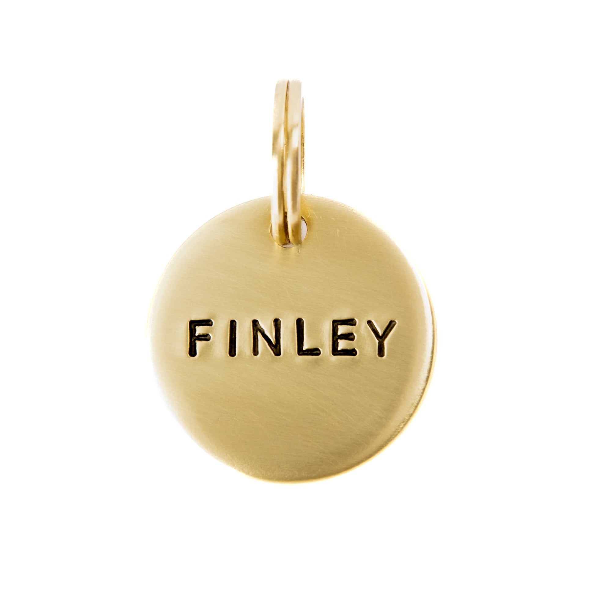 Round brass pet name tag personalized, on a white background. 