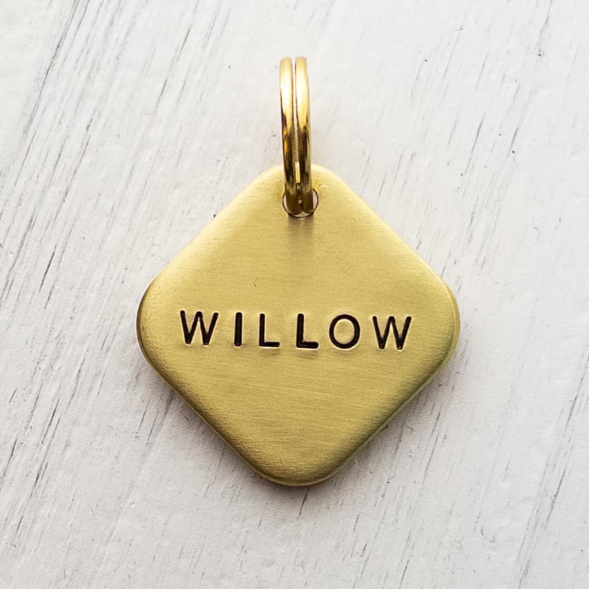Diamond-shaped brass dog ID tag with jump ring.