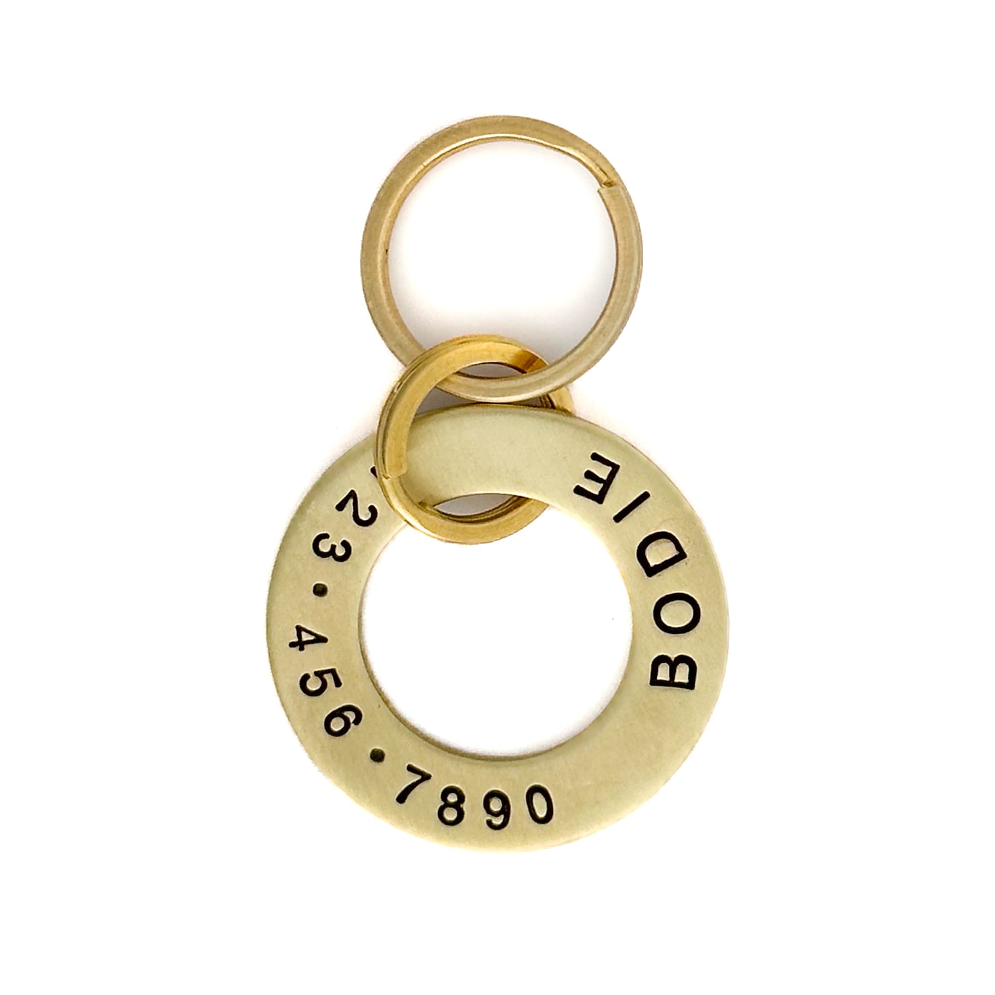 Brass washer style dog name tag engraved with name and phone number.